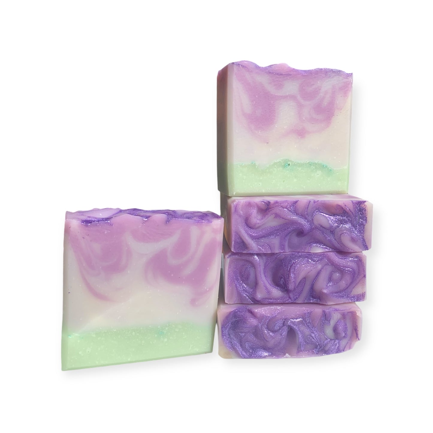 Swirled purple and green soap bars on a white background
