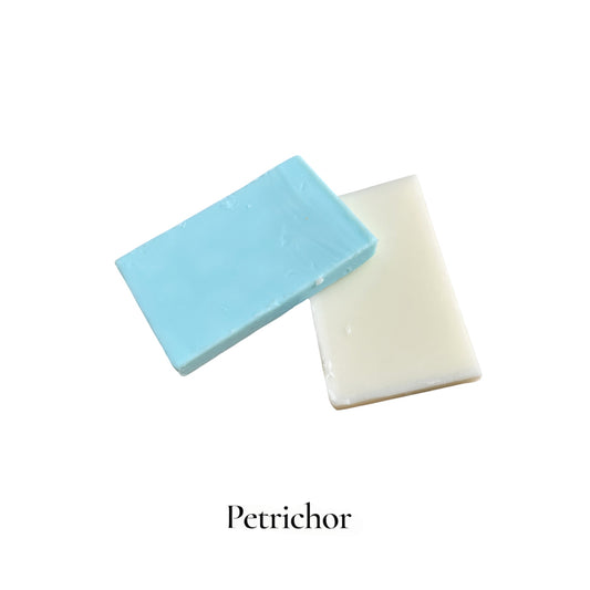 Two bars of soap, one blue and one white, on a white background with 'Petrichor' branding.
