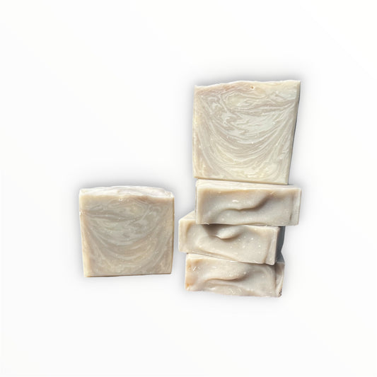 Four rectangular bars of handmade soap with a swirled cream and light beige pattern, arranged on a plain white background.