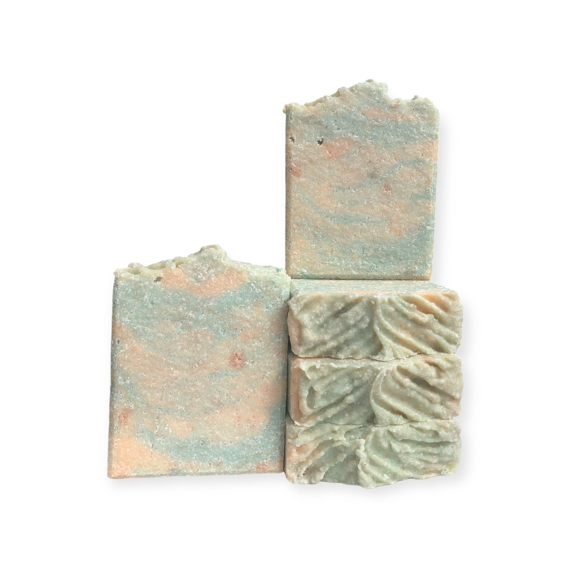 Green and yellow soap bars with marbled patterns on a white background
