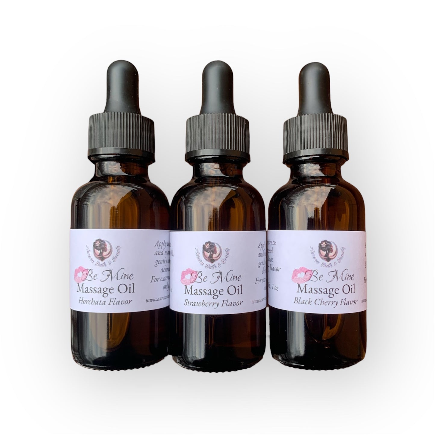Three bottles of 'Be Mine' Massage Oil with dropper caps on a white background