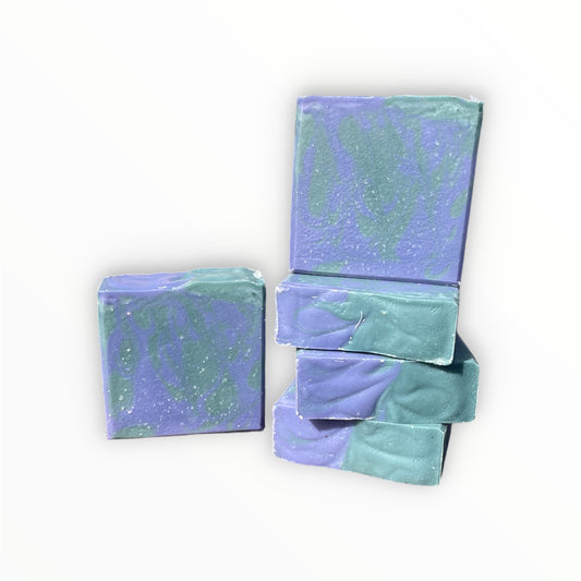 Five bars of marbled purple and green soap arranged on a plain white background.