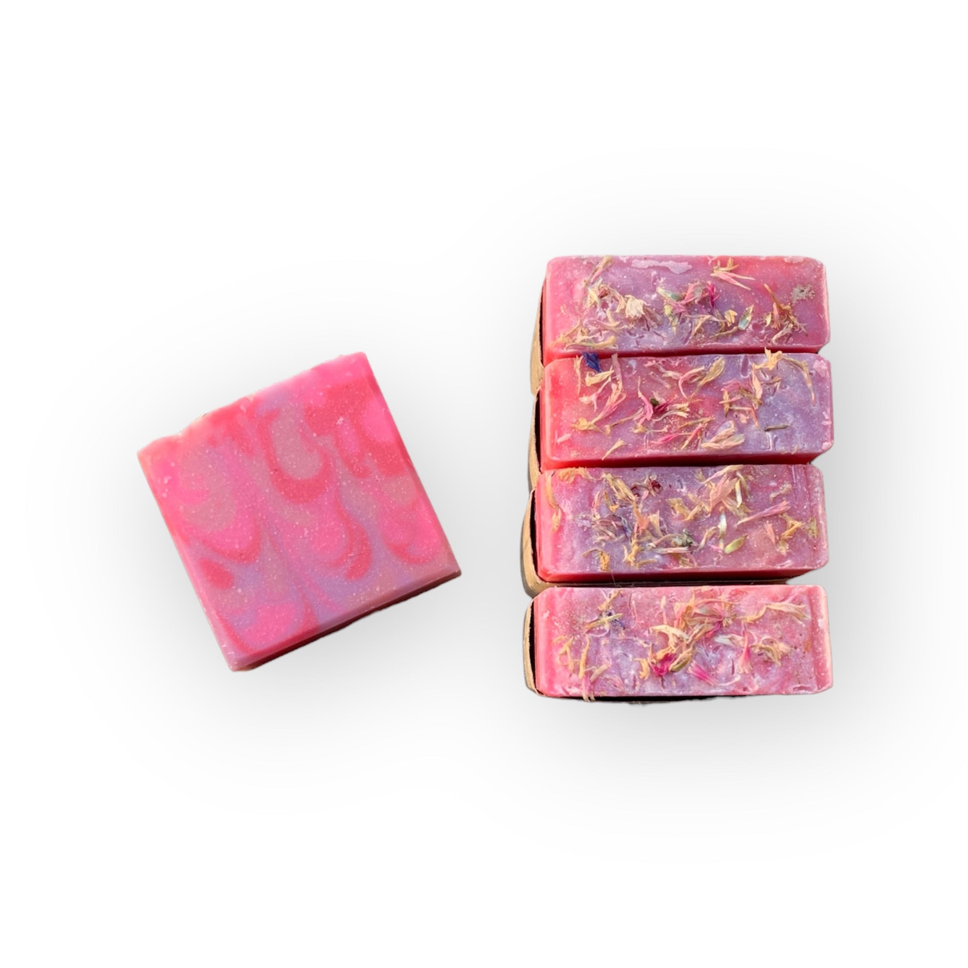 Pink, purple, and red marbled soap bars on a white background