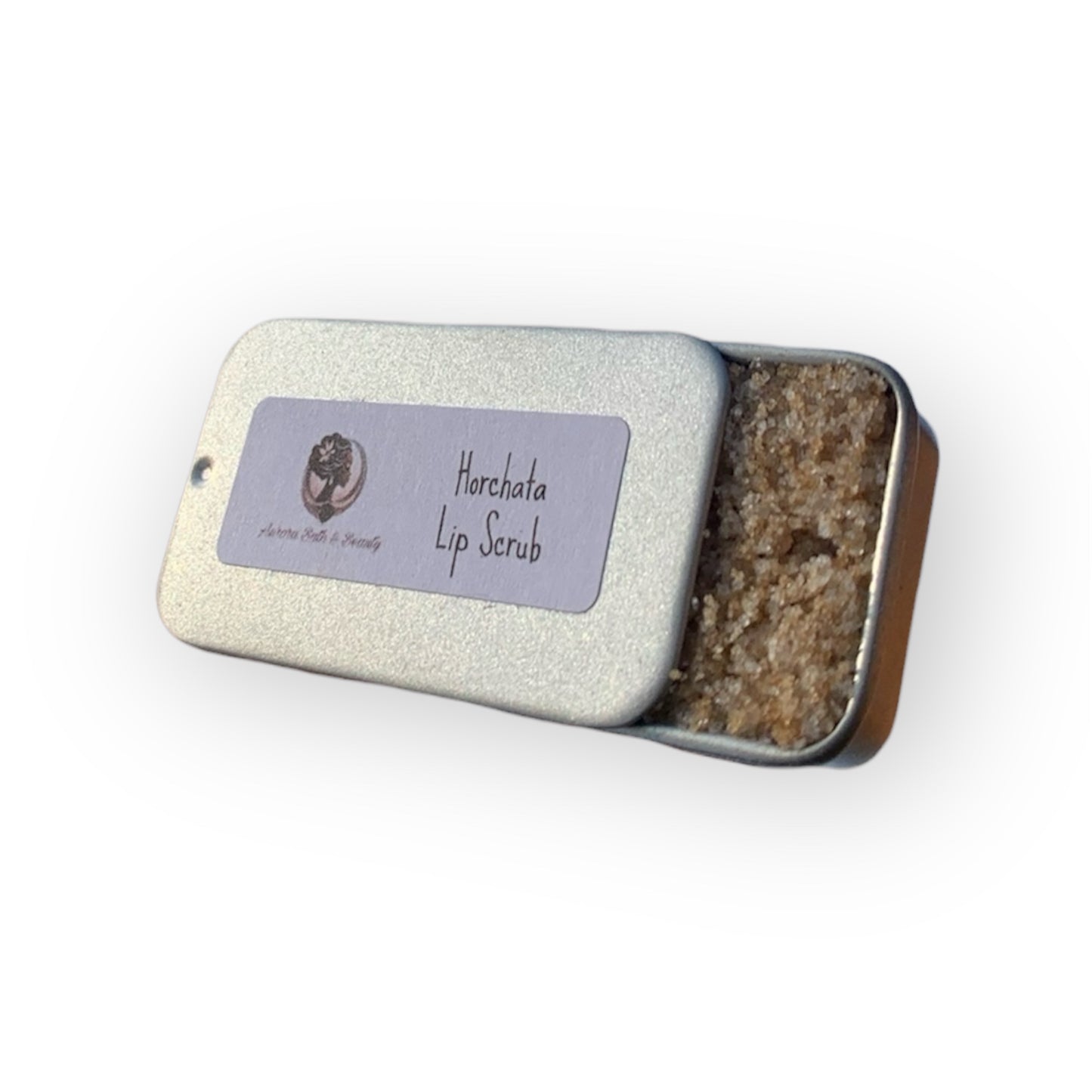 Lip scrub in a metal tin with a label on a white background
