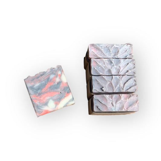 Black, red, and white marble-patterned soap bars with a box on a white background