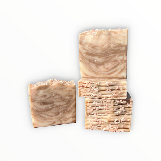 Five bars of marbled soap with a swirled beige and light brown pattern and textured beige tops, arranged on a plain white background.