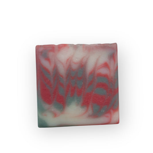 Marbled soap bar with red, green, and white colors on a white background