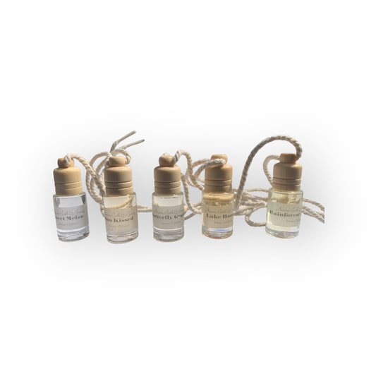 Set of five small glass bottles with gold caps on a white background