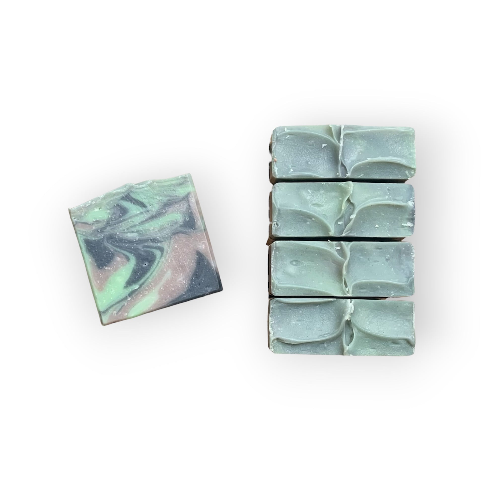 Marble-patterned green, black, and brown soap bars on a white background